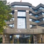 Illustration d'une main tenant un stylo et pointant un document fiscal, symbolisant la note circulaire de la DGI sur la Loi de Finances 2026.