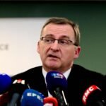 Vue de l'entrée de Sciences Po Lyon, des silhouettes floues de manifestants en arrière-plan, symbolisant les affrontements ayant mené au drame.