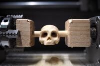 A Makera Carvera Air CNC machine carving a detailed skull model.