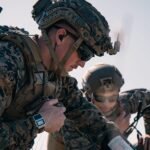 A Marine operating a military drone with a desert landscape in the background, symbolizing advanced training.