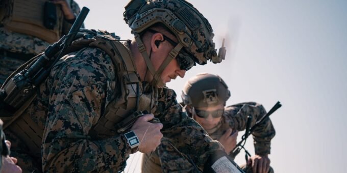 A Marine operating a military drone with a desert landscape in the background, symbolizing advanced training.