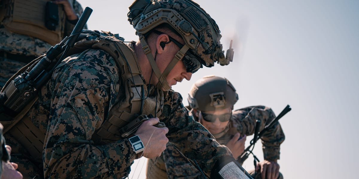 A Marine operating a military drone with a desert landscape in the background, symbolizing advanced training.