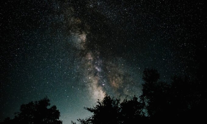 Astrological chart with Mercury retrograde symbol over a background of fish representing Pisces.