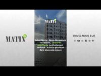 Vue aérienne d'une ville du nord du Maroc sous la pluie, avec des nuages sombres et des flaques d'eau reflétant le ciel.