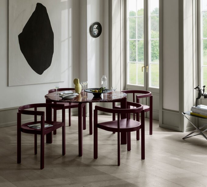 The After Series dining collection by Michael Anastassiades for Fritz Hansen, featuring a burgundy oak chair and a table with a Rosso Levanto marble top.