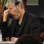 Strategy's Bitcoin Holdings Dip Below Cost: Why Michael Saylor Isn't Sounding the Alarm 8 Michael Saylor speaking at a cryptocurrency conference with a Bitcoin logo in the background.