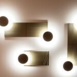 Modular ARID Wall Lighting system by Nahtrang Studio for Bover, showcasing customizable light nodes and colored back panels on a wall.