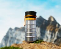 The MokaMax Portable Coffee Pot, a sleek, ribbed aluminum device for brewing fresh coffee on the go.