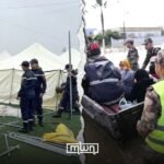 Aerial view of flooded agricultural plains and submerged towns in Northern Morocco, with rescue teams operating.