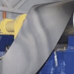 Morocco's Steel Sector Under Pressure Amidst Global Overcapacity Surge 6 A steel mill in Morocco with a backdrop of global trade graphs, symbolizing the industry's struggle with overcapacity.