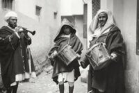 Un neffar marocain, vêtu d'une tenue traditionnelle, soufflant dans sa trompette avant l'aube pour réveiller les fidèles pendant le Ramadan.