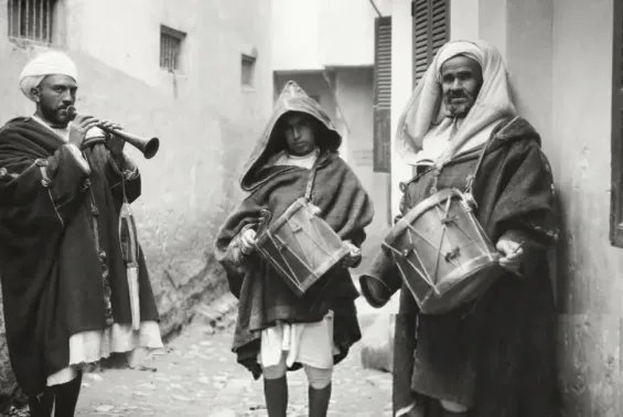 Un neffar marocain, vêtu d'une tenue traditionnelle, soufflant dans sa trompette avant l'aube pour réveiller les fidèles pendant le Ramadan.