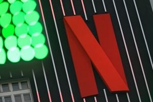 Netflix logo against a backdrop of financial charts, symbolizing its strategic withdrawal from the Warner Bros. Discovery bidding war.