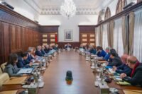 Photo du Chef du gouvernement Aziz Akhannouch présidant un Conseil de gouvernement, avec des documents et des officiels en arrière-plan.