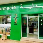 Un pharmacien en blouse blanche, symbolisant la profession, avec des médicaments en arrière-plan, illustrant la controverse sur l'ouverture du capital des pharmacies au Maroc.