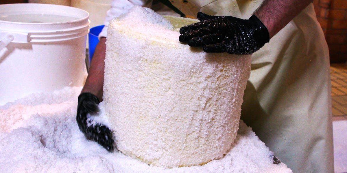 A wheel of authentic Pecorino Romano cheese aging in a traditional cellar in Lazio, Italy