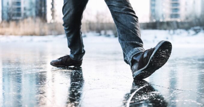 A person attempting to climb out of a large, carved ice bowl, illustrating the physics challenge.