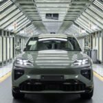 Vue d'ensemble de la ligne de production du Porsche Cayenne électrique à l'usine Volkswagen de Bratislava, montrant des véhicules en cours d'assemblage et des robots industriels.