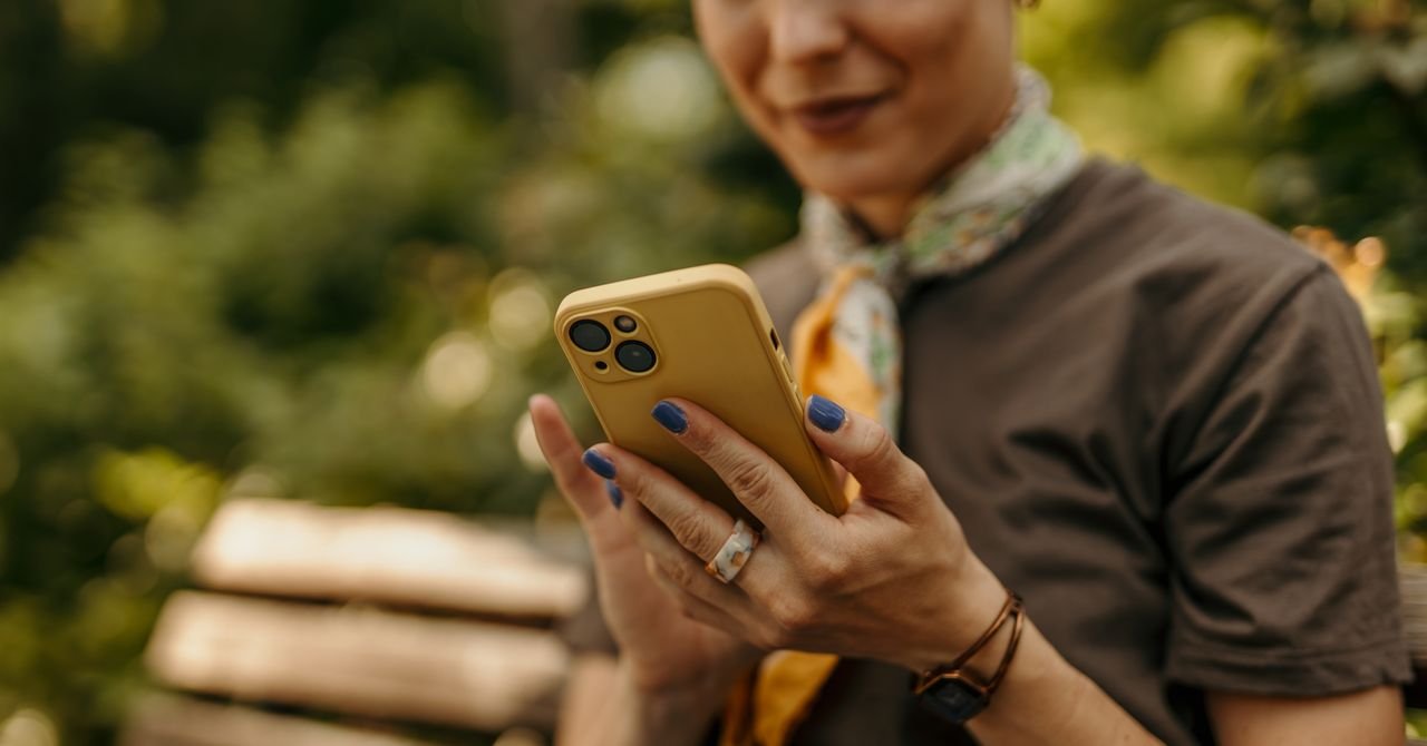 Person holding a smartphone with network signal bars, illustrating the freedom and flexibility of prepaid phone service.