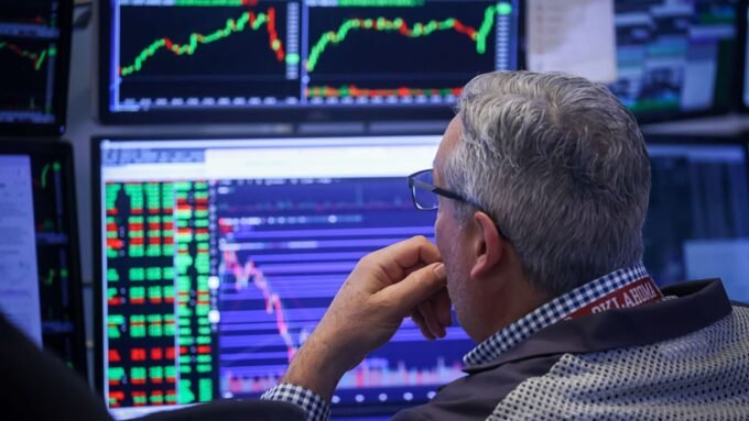 A trader works on the floor of the New York Stock Exchange, symbolizing financial market activity and potential volatility.