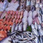 La flambée des prix du poisson au Maroc pendant le Ramadan : une parlementaire dénonce une situation 'injustifiée' 6 Un étal de poisson frais dans un marché marocain, avec des prix affichés, symbolisant la cherté dénoncée