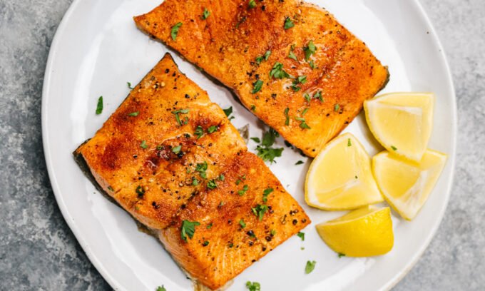 A vibrant selection of high-protein foods including salmon, cottage cheese, tofu, tuna, and shrimp, arranged appealingly on a table.