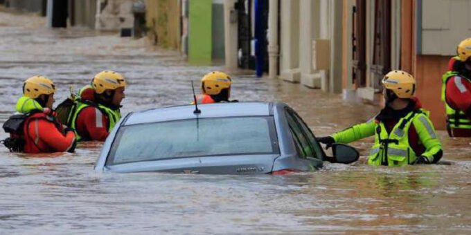 Une image symbolisant les aléas climatiques en Europe, comme une ville partiellement inondée, ou un paysage aride sous un soleil de plomb, avec des silhouettes de personnes en arrière-plan.