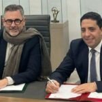 Révolution Verte au Maroc : Stellantis et Attawfiq Microfinance Accélèrent l'Électromobilité pour les TPE 4 Deux dirigeants, Yves Peyrot Des Gachons de Stellantis Maroc et Hicham Kharrou d'Attawfiq Microfinance, se serrent la main devant un tricycle électrique FIAT TRIS, symbolisant leur partenariat pour la mobilité verte au Maroc.