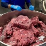 Professional chefs working in a highly secure kitchen at Rikers Island jail, preparing meals for detainees.