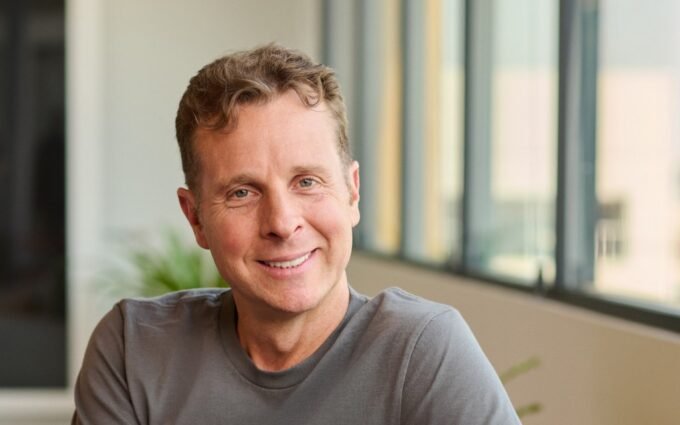 Jamie Siminoff, founder of Ring, standing with a Ring video doorbell