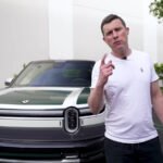 Rivian R2 en action, mettant en avant son design robuste et ses lignes distinctives, avec un arrière ouvert.
