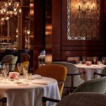 Vue élégante de l'intérieur d'un des restaurants du Royal Mansour Marrakech, avec une table dressée et un éclairage chaleureux.