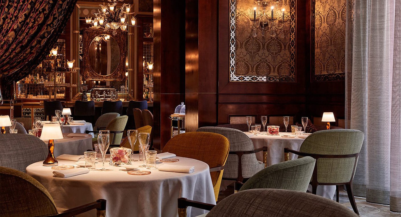 Vue élégante de l'intérieur d'un des restaurants du Royal Mansour Marrakech, avec une table dressée et un éclairage chaleureux.