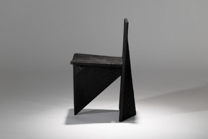 The Century Chair: Satoshi Itasaka's Masterpiece Carved from Time Itself 7 The angular and sculptural Century Chair by Satoshi Itasaka, carved from a single block of solid wood, showcasing its natural grain.