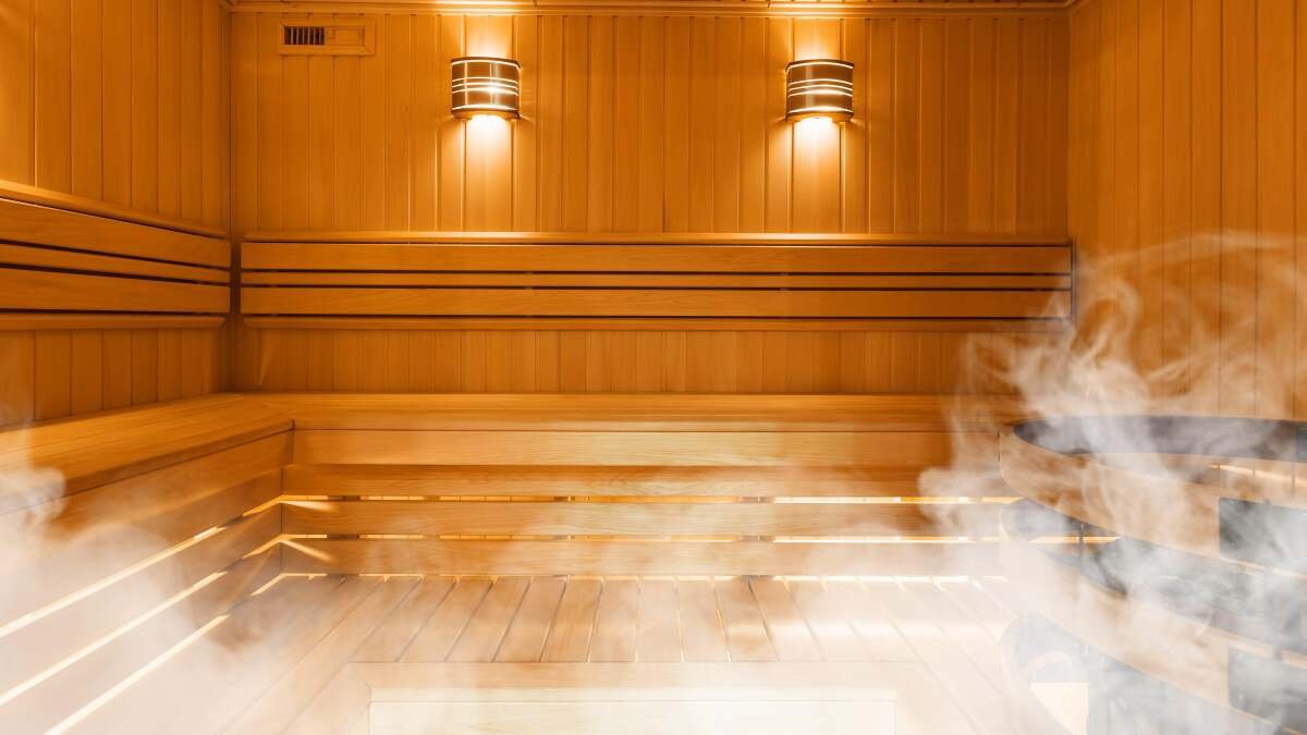 Saunas: Your Guide to Real Benefits and Debunked Myths 3 A person relaxing in a traditional wooden sauna, surrounded by steam and warmth.