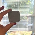 A smartphone being tapped against 'The Brick' device, illustrating screen time management.