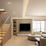 Interior view of a modern Hong Kong duplex living space with curved walls, textured surfaces, and sculptural lighting, overlooking Repulse Bay.