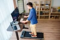 A person walking on a compact treadmill in a modern home setting, illustrating convenience and space-saving design.