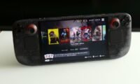 A Steam Deck handheld console displaying a game, with a backdrop suggesting a technological or futuristic theme.