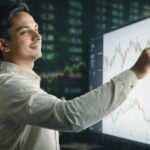 Mastering Stock Evaluation: Your Essential Guide to Smart Investing 4 A person analyzing stock charts on a computer with financial graphs in the background, representing stock evaluation.