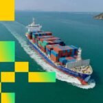 An oil tanker navigating the narrow, strategic waters of the Strait of Hormuz, with land visible on either side.