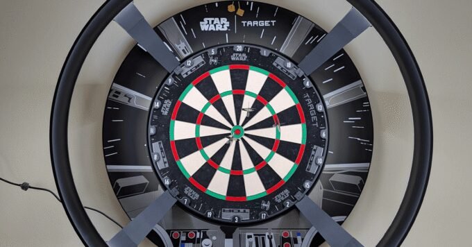Target Darts Omni Auto Scoring System mounted on a dartboard, illuminated by its LED ring.