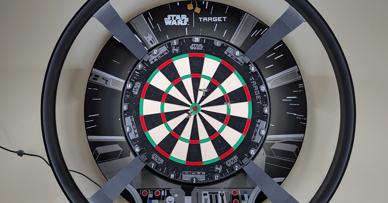 Target Darts Omni Auto Scoring System mounted on a dartboard, illuminated by its LED ring.