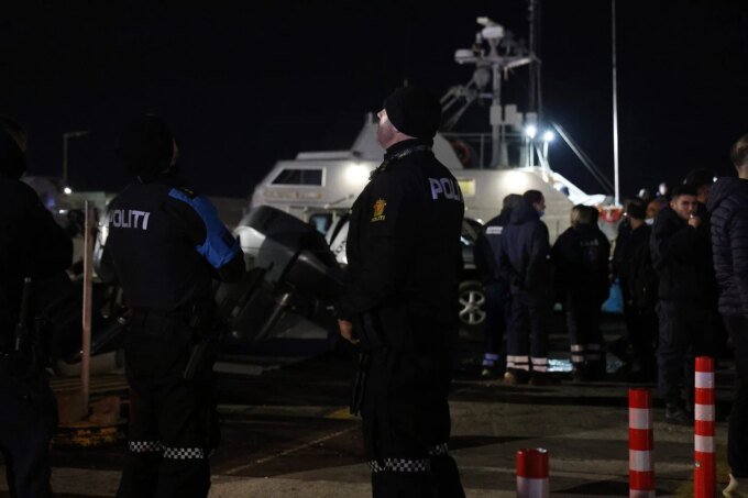 Illustration d'une embarcation de migrants en mer, avec des garde-côtes en arrière-plan, symbolisant une opération de sauvetage ou un drame maritime.