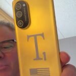 A render or screenshot of the Trump Mobile T1 Phone, featuring its gold finish and redesigned vertical camera island.