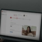 A person using the TurboTax mobile app on a smartphone to file their taxes, with a calculator and documents nearby.