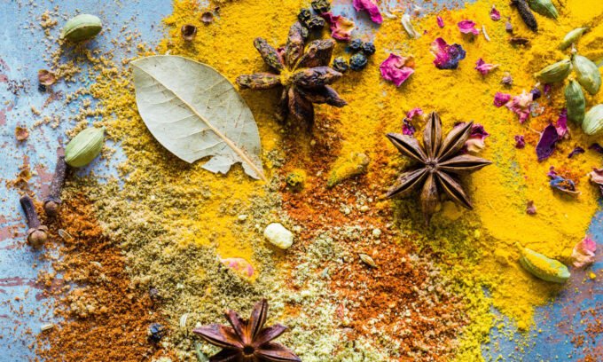 A vibrant yellow turmeric root and ground turmeric powder, symbolizing its health benefits and culinary uses.