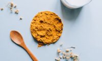 Golden turmeric root and powder, symbolizing natural relief for PMS symptoms.