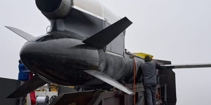 An illustration of a Ukrainian-designed long-range missile, possibly the 'Flamingo', striking a factory building in a distant Russian region.