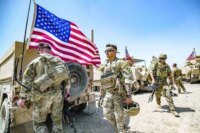 US troops with an American flag in Syria, symbolizing the end of a decade-long military presence.